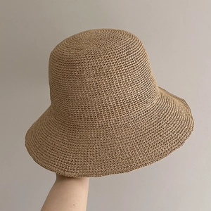 Close-up of the delicate handmade crochet texture and khaki straw weaving on the sun hat