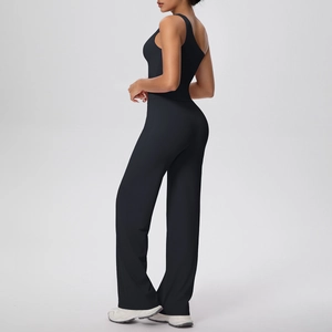 Détail du design asymétrique à une épaule et du pantalon de yoga noir à jambes larges