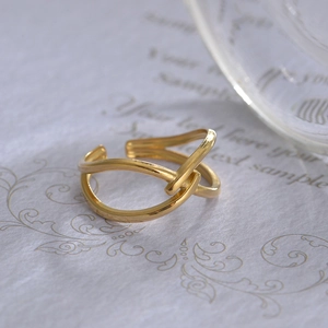 Detailed close-up of a 14K gold-plated interlocking knot ring on an elegant background