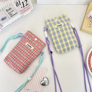 Detail of checkered canvas crossbody bags with adjustable braided straps and snap closure