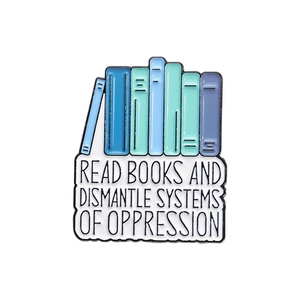 Enamel pin featuring colorful books and slogan about reading and dismantling systems