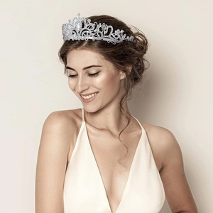 Close-up of elegant silver rhinestone crown featuring ornate leaf and scroll details