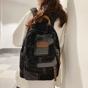 Denim patchwork backpack with leather details shown from a stylish side perspective
