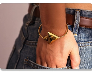 Close-up of 18K gold-plated stainless steel geometric bangle worn on a model wrist