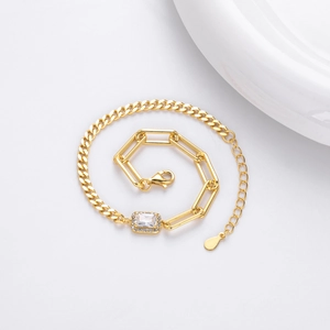 Detail of gold-plated cuban and paperclip chain bracelet with a square zircon stone