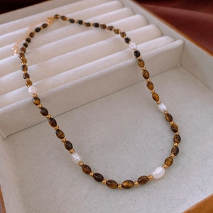 Détail du collier de perles d'eau douce avec perles d'oeil de tigre dans un coffret