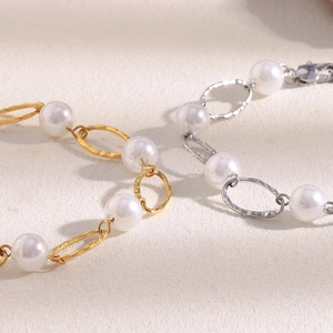 Macro view of 18K gold plated and silver hammered oval metal rings with pearls