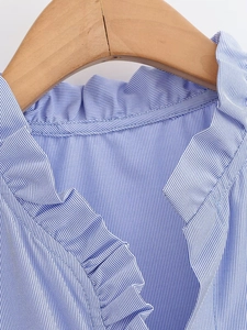 Detailed close-up of ruffle collar on blue and white striped cotton poplin shirt