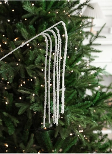 Close-up of elegant white pearl bead sprays on a Christmas tree with warm festive lighting