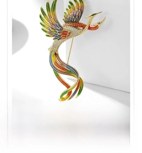 Detail of vintage phoenix enamel brooch with colorful crystals and gold plating