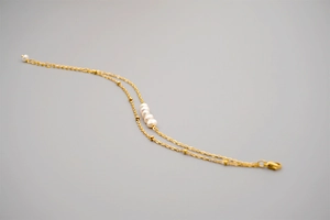 Detail of double-layer gold titanium bracelet featuring natural pearls and tiny gold beads