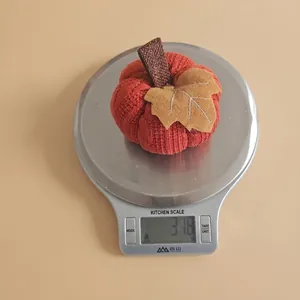Close-up showing a knit orange pumpkin decoration weighing 31.8g on a digital scale