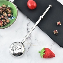 Macro view of long handle stainless steel tea infuser ball on marble background