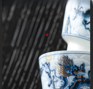Macro detail of hand-painted blue dragon and gold inlay craftsmanship on ceramic teacup