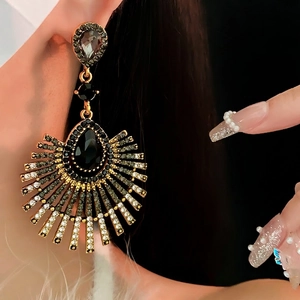 Vintage gold teardrop fringe earrings with black crystal rhinestones worn on ear
