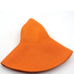 Macro shot of orange sun hat featuring high-density spiral woven paper straw texture
