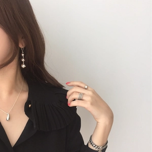 Close-up of elegant silver water-drop earrings and matching accessories set on model