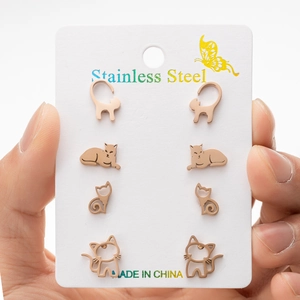 Detailed view of four pairs of rose gold stainless steel cat stud earrings on a card