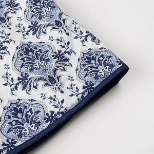 Close-up of vintage blue paisley floral print on cotton jacket with satin piped edges