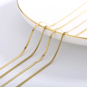 Detailed close-up of double-layered gold snake and pearl box chains on a white plate