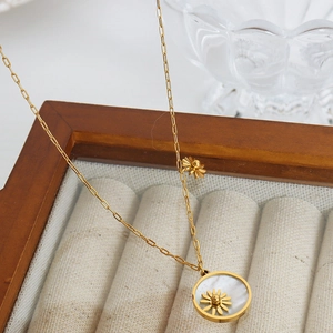 Golden titanium steel necklace featuring a white shell coin pendant with a daisy flower