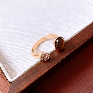 Detail of 18K gold-plated open ring with tiger eye stone and micro-set zirconia crystals