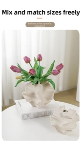 Detailed view of matte white ceramic vases with unique pleated texture and organic shape