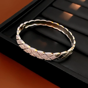 Macro detail of silver quilted bangle with micro-paved cubic zirconia in a jewelry box