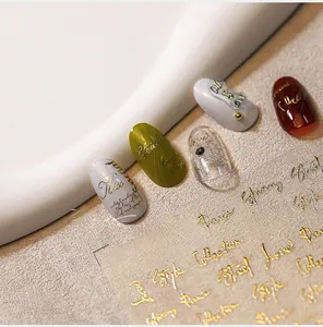 Detail of 3D embossed gold foil butterfly nail stickers with cursive English lettering