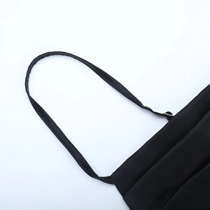 Detailed view of black satin dress featuring delicate thin spaghetti straps and glossy fabric