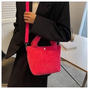 Detail of neon pink corduroy tote bag showing striped texture and detachable strap