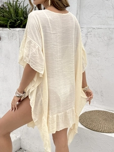 Detail of cream beach cover-up with ruffle hem and lightweight semi-sheer fabric