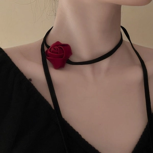 Detail of red fabric rose choker with long black ribbon tie on model's neck