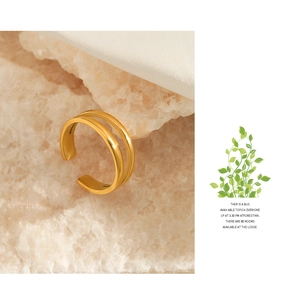 Macro detail of double-layered gold-plated stainless steel open ring on a textured rock