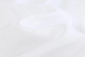 Macro detail of breathable white linen fabric texture on long sleeve casual shirt