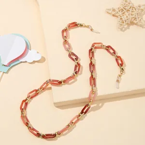 Dettaglio delle maglie in acrilico rosa e ganci dorati su una catena per occhiali moda