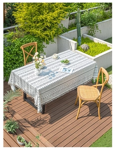 Detail of bohemian tablecloth with black geometric patterns and elegant white fringe