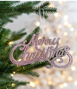 Glittery pink Merry Christmas letter hanging ornament on a green tree branch
