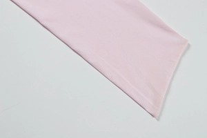 Détail de la texture plissée rose pâle et des coutures fines sur une robe ajustée