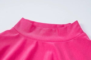 Dettaglio dell'abito fucsia a maniche lunghe con trama del tessuto in maglia a coste