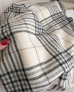 Close-up of beige and black plaid cashmere-like scarf fabric showing soft texture