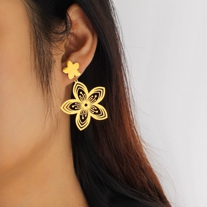 Detail view of 18k gold flower earring with transparent petals on female model's ear