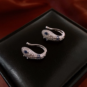 Detail of silver snake ear cuff with white zircons and blue gemstone accents