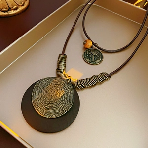 Détail du collier vintage avec breloques en bronze et pendentifs ronds en bois sur cuir