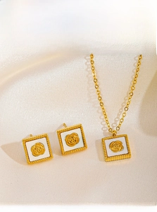Detailed macro view of square white shell necklace and earrings with gold rose accents
