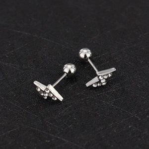 Macro detail of silver lightning-shaped screw-back stud earring with clear zircons