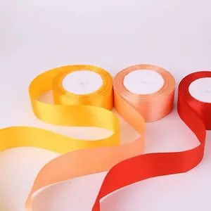 Rolls of 4cm glossy satin ribbons in yellow, orange, and red for gift wrapping and DIY crafts
