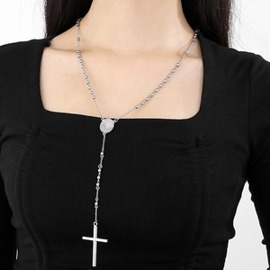 Detail of silver rosary necklace with oval medal and cross pendant on a model