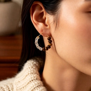 Detail shot of vintage tiger eye and crystal beaded hoop earrings on model