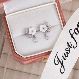 Detailed macro of pink zircon flower earrings in a premium pink velvet jewelry box